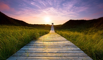 Boardwalk beneath a colorful evening sky.